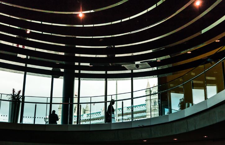 Silhouette Of A Woman Walking Through A Large Office Stairway