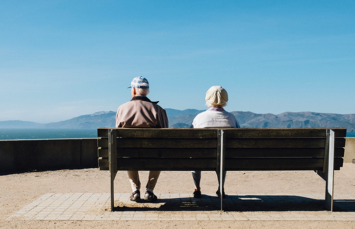 Elderly Couple Sitting Far Apart On A Bench